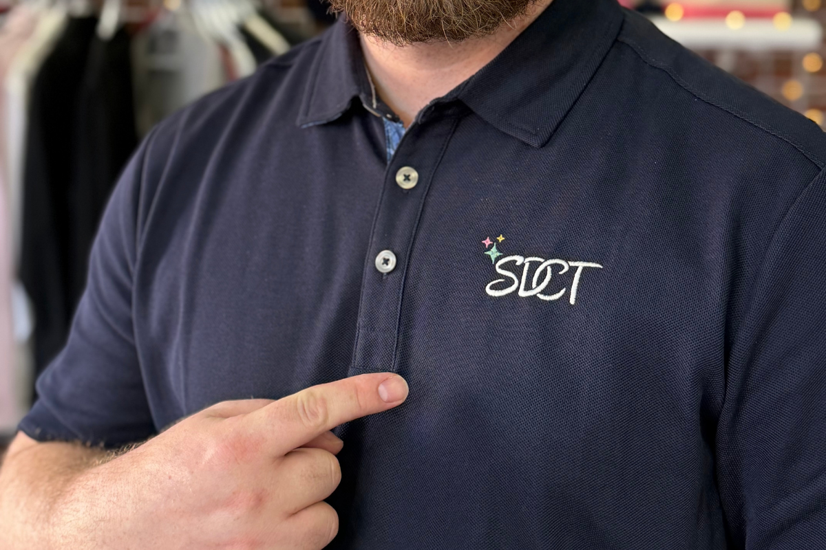 Close-up of SDCT embroidered logo apparel on Tommy Bahama polo shirt